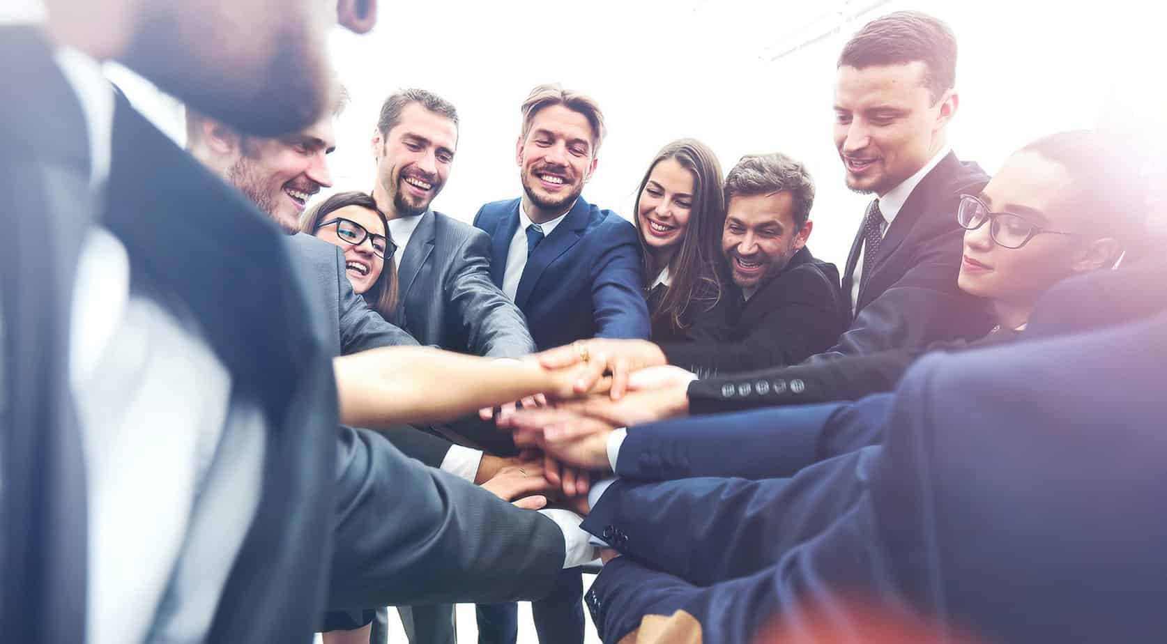 Diverse business team stacking hands together in unity and teamwork